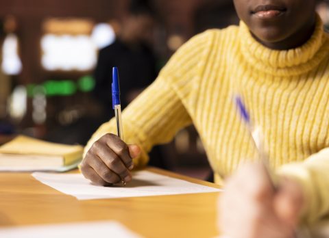 Diverse classmates brainstorming and writing ideas for a project